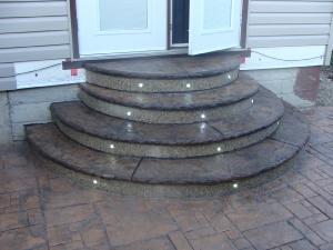 Decorative stamped concrete steps with lights on