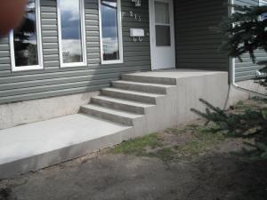 Concrete steps and sidewalk beside house