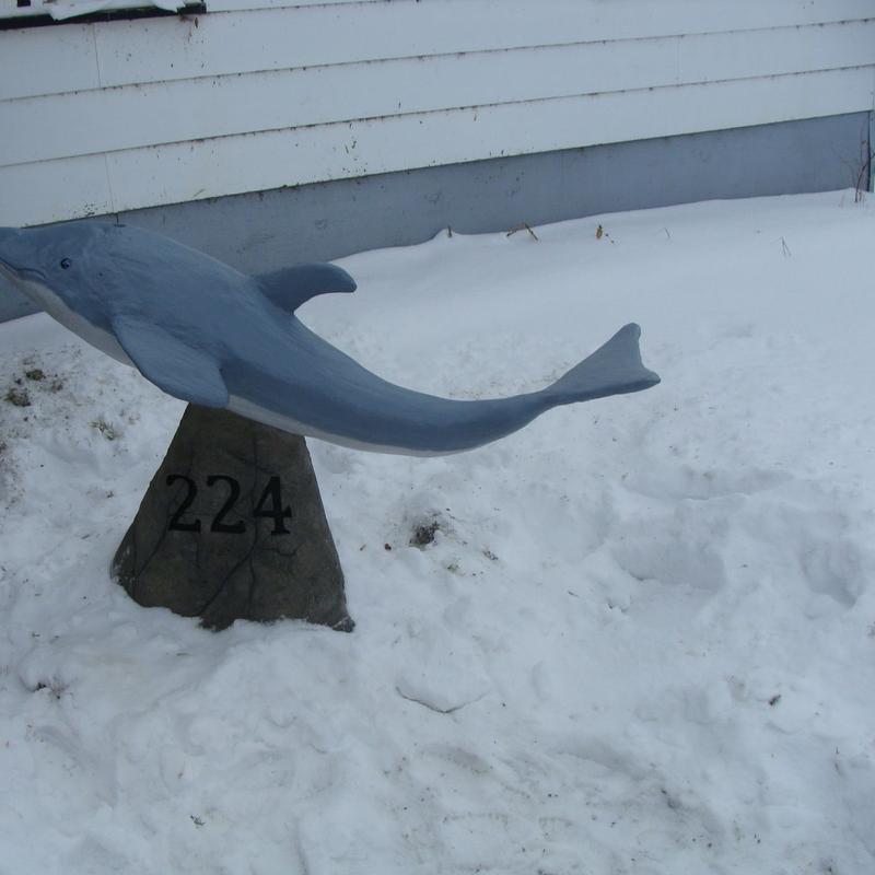 Concrete dolphin sculpture with house number